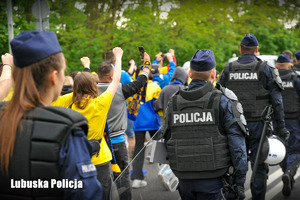 Policjanci prowadzą kibiców na stadion