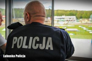 Policjant, w tle stadion żużlowy