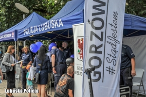 Policjanci i przybyli goście uroczystości przy stoisku profilaktycznym