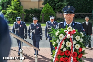 Policjant z wieńcem na tle innych policjantów