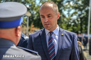 Mężczyzna wręcza gratulacje policjantowi