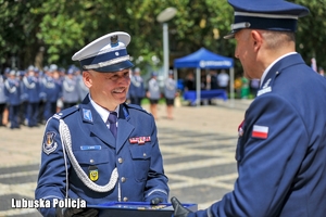 Policjanci przekazują tace z odznaczeniami