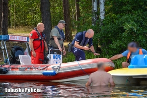 Policjanci rozmawiają z osobami przebywającymi na jeziorze