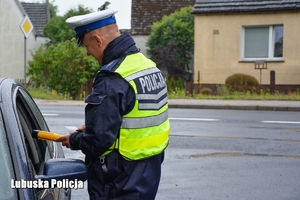 Policjant ruchu drogowego przy kontroli trzeźwości kierowcy