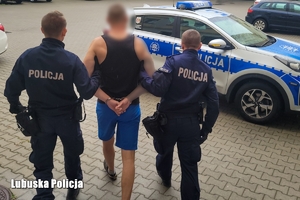 Policjanci prowadzą osobę podejrzaną