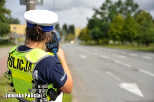 Policjantka ruchu drogowego mierzy prędkość pojazdów