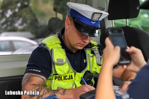 Policjant wypisuje mandat