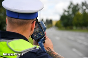 Policjant ruchu drogowego mierzy prędkość pojazdów