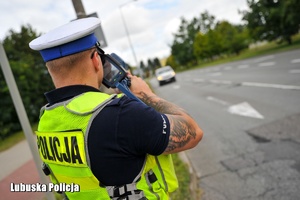 Policjant ruchu drogowego mierzy prędkość pojazdów
