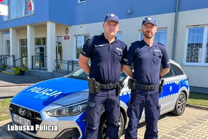 Policjanci na tle radiowozu