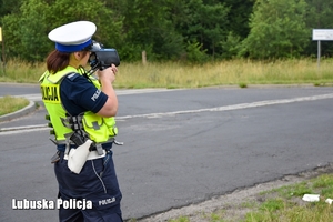 Policjantka mierząca prędkość na drodze.