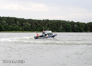 Policjanci płynący łodzią po jeziorze.