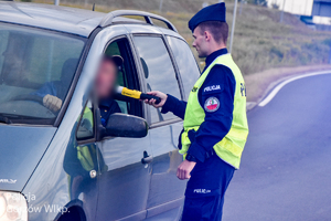 Policjant ruchu drogowego przy badaniu trzeźwości kierowcy