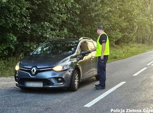 Policjant ruchu drogowego przy badaniu trzeźwości kierowcy