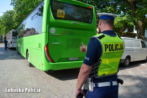 Policjant sprawdzający stan techniczny autobusu