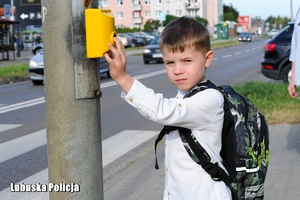 Dziecko wciskające przycisk na światłach przy przejściu dla pieszych