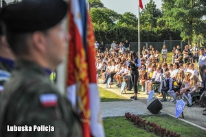 Dzieci siedzą na krzesłach na rozpoczęciu roku szkolnego.