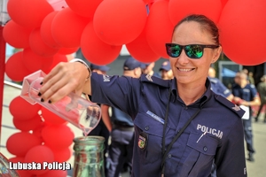 policjantka wlewa czerwony płyn do butli