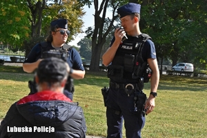 policjanci rozmawiają z osobą w parku