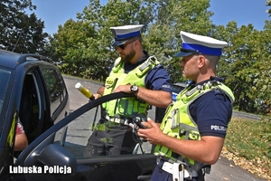 policjanci prowadzą kontrolę drogową