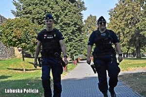 policjanci idą przez park