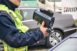 Policjant pokazuje urządzenie do pomiaru prędkości