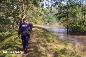 Policjanci wraz z strażakami kontrolują stan wody