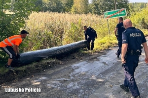 Policjanci pomagają przy zabezpieczeniu przed powodzią