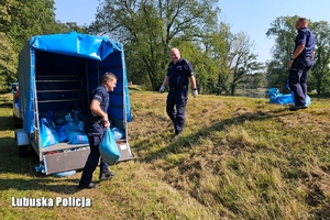 Policjanci przygotowują worki do zabezpieczenia wału