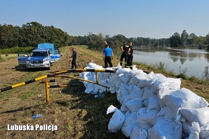 Policjanci przygotowują worki do zabezpieczenia wału