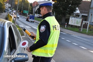 Policjant ruchu drogowego sprawdzający trzeźwość kierowcy.