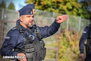 Policjant wskazuje ręką kierunek