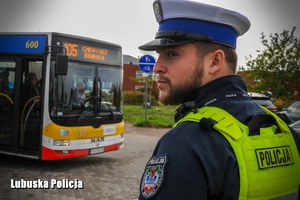 Policjant przy autobusie, patrolujący okolicę