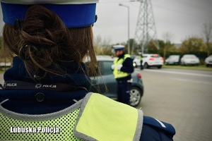 policjantka obserwuje ruch pojazdów na drodze