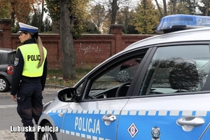 policjantka obserwuje ruch pojazdów na drodze