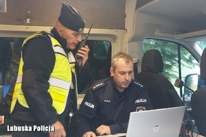 policjanci spoglądają na laptopa