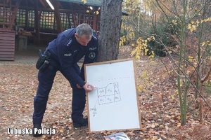 policjant wskazuje na tablicę