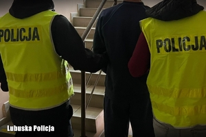 policjanci prowadzą podejrzanego mężczyznę