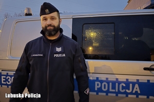 policjant stoi przy radiowozie