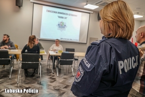 Policjantka obserwuje pracowników podczas ćwiczeń