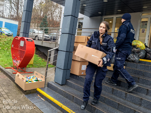 policjantka niesie karton z nakrętkami