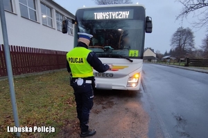 policjant kontroluje stan techniczny autokaru