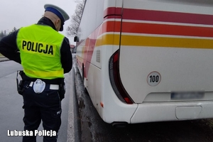 policjant kontroluje stan techniczny autokaru