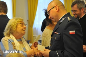 Policjant składa życzenia bożonarodzeniowe i dzieli się opłatkiem