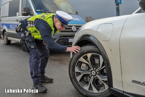 policjant kontroluje ogumienie pojazdu