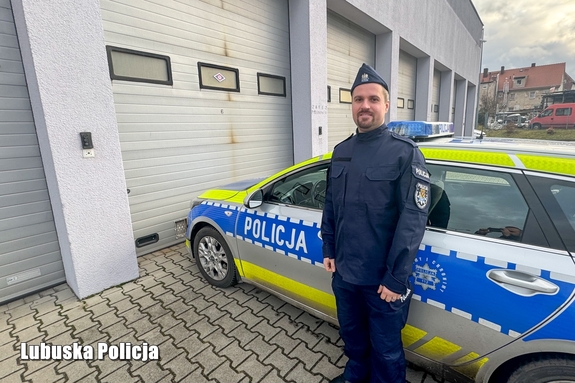 Policjant na tle radiowozu