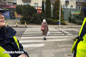 Policjanci, w tle widoczna kobieta przechodząca przez pasy