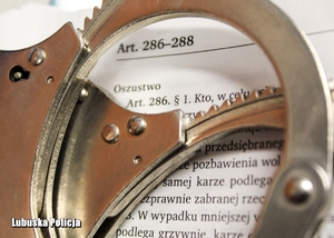 Kajdanki w tle widoczny napis &quot;Oszustwo&quot;