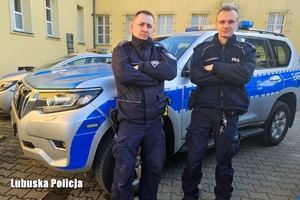 Policjanci na tle radiowozu