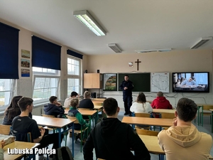 Policjant podczas akcji profilaktycznej w klasie szkolnej.